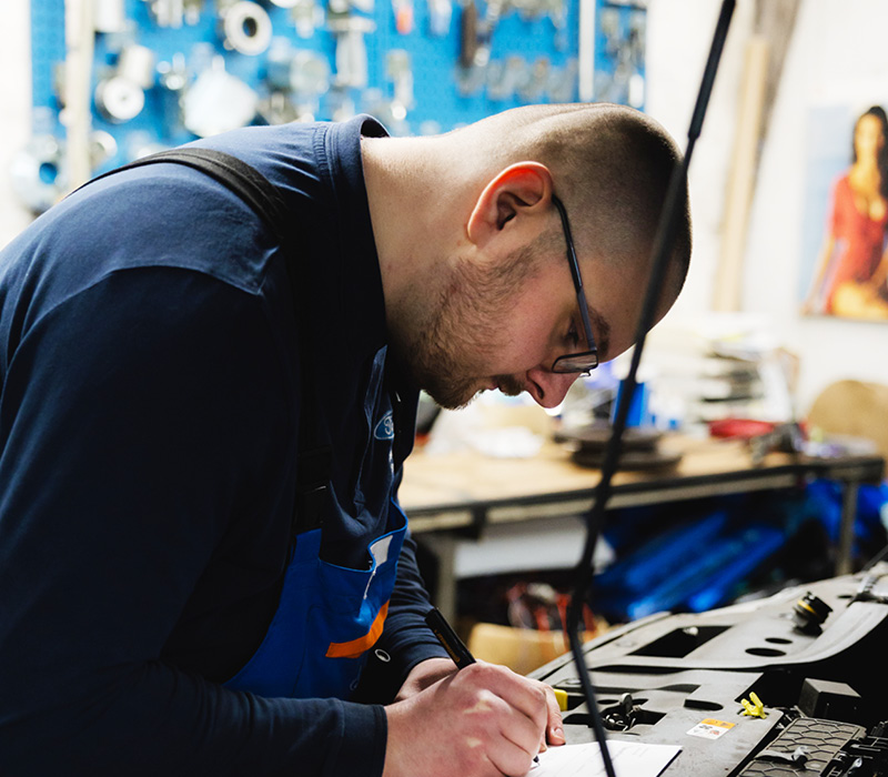 Mitarbeiter notiert Infos zum Fahrzeug